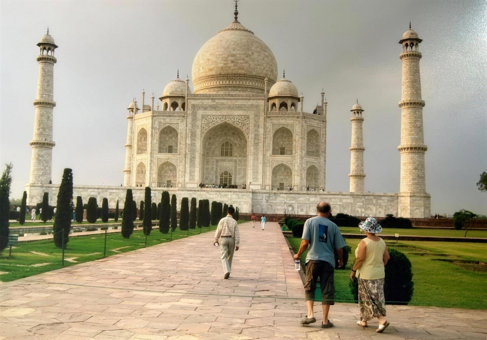 Bernard walking the long path toward the Taj Mahal under a heavy sky — his own photograph from the journey he describes here